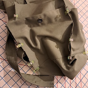 A close-up showing the sides of an olive green bag held together using wonderclips.