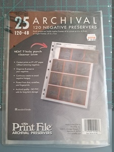 A package of archival print sleeves for 120 mm negatives resting on a cutting mat.