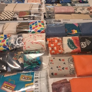 View of several negative sleeves containing brightly coloured fabric scraps arranged on a table..