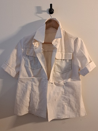 The front of the pattern envelope for Vogue pattern V1966, showing a drawing of a tall, skinny woman wearing two views of a collared shirt, with long and short sleeves, respectively, as well as a pair of flowy pants.